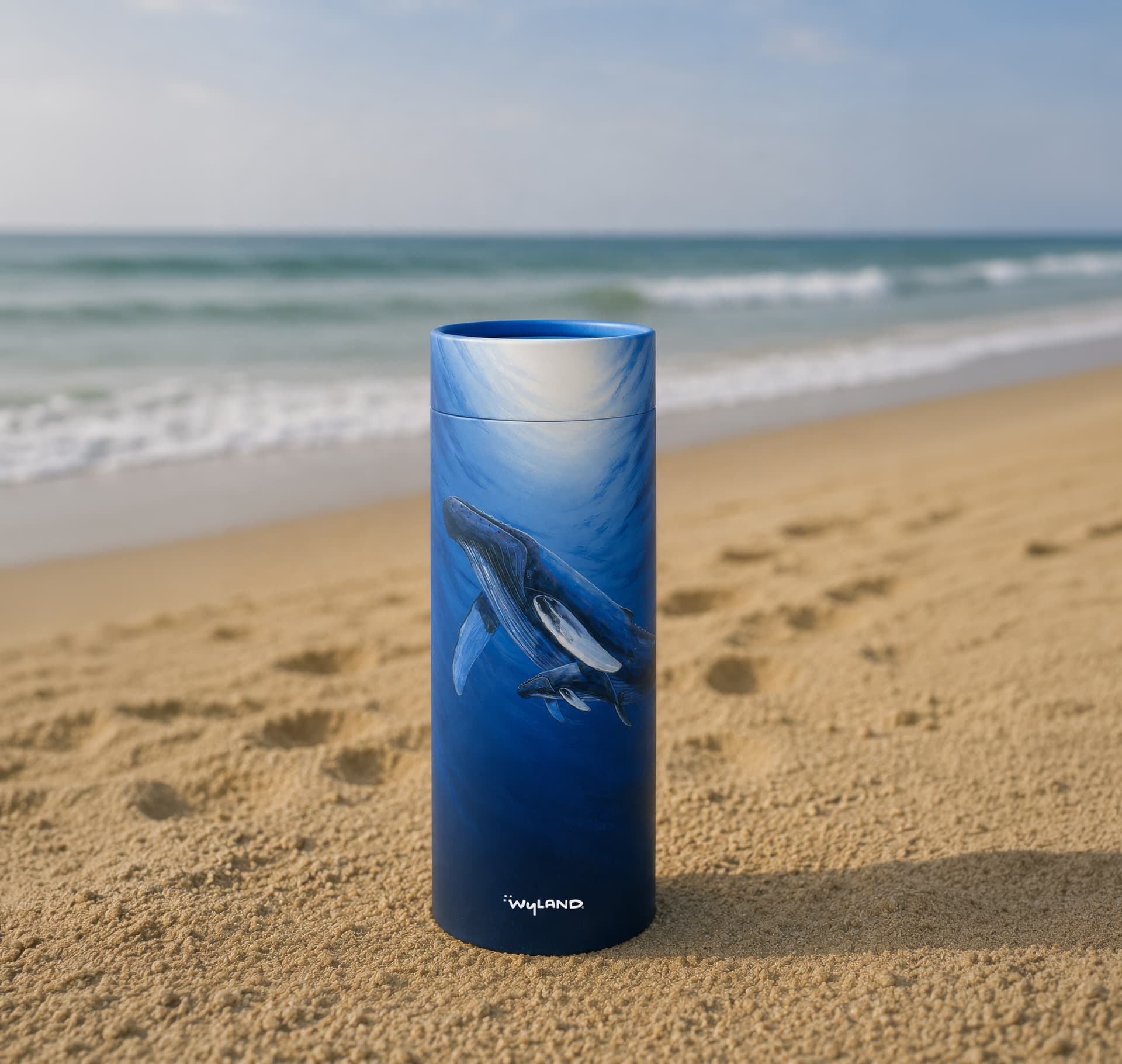 Scattering Tube with Wyland's humpback whale and newborn artwork, standing on a beach