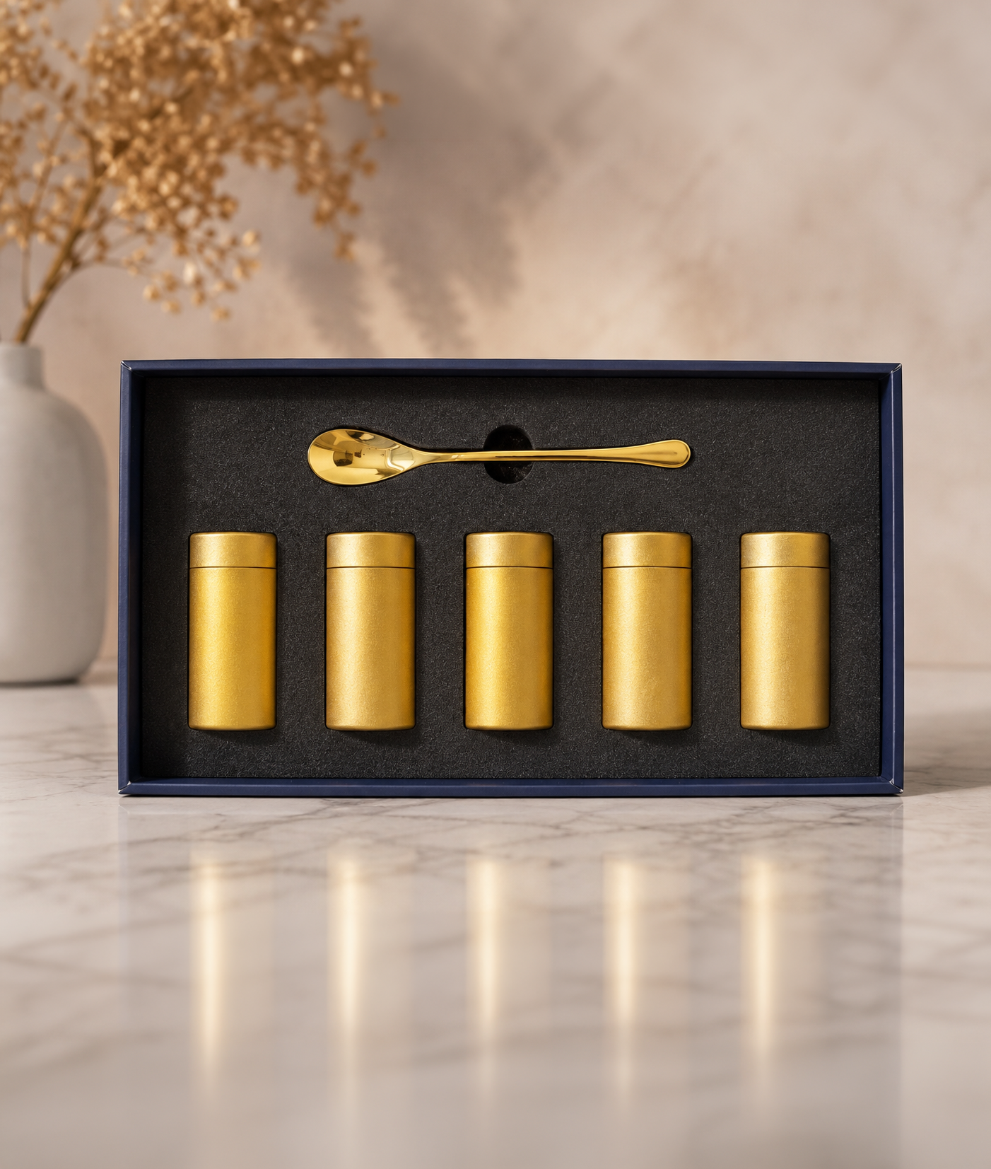 FamilyShare open box showing five gold keepsake canisters and a gold spoon on a fitted black interior